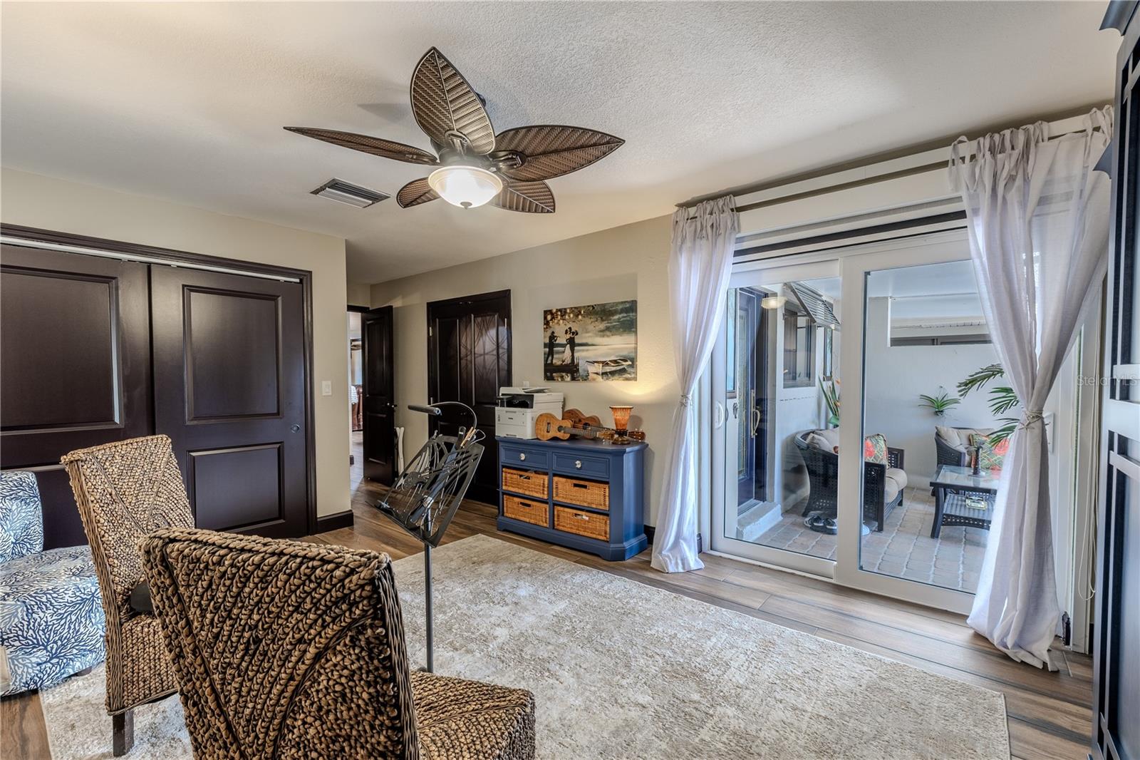 Sliding glass doors open to the front courtyard and feature both a retractable screen and a pull-down shade, allowing fresh air and natural light while maintaining privacy.