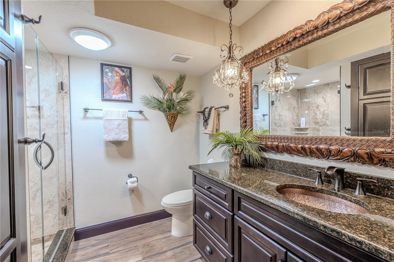 The second bathroom features elegant stone counters, custom cabinetry, and thoughtful built-in storage that keeps essentials neatly organized.