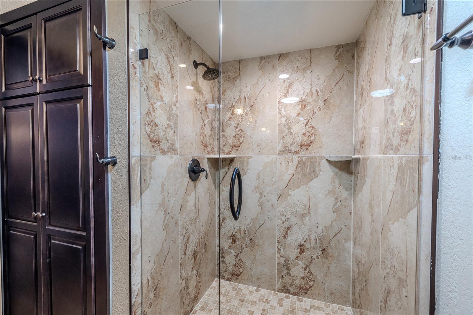 A frameless glass shower with floor-to-ceiling tile and modern fixtures gives the guest bath a clean, polished look.