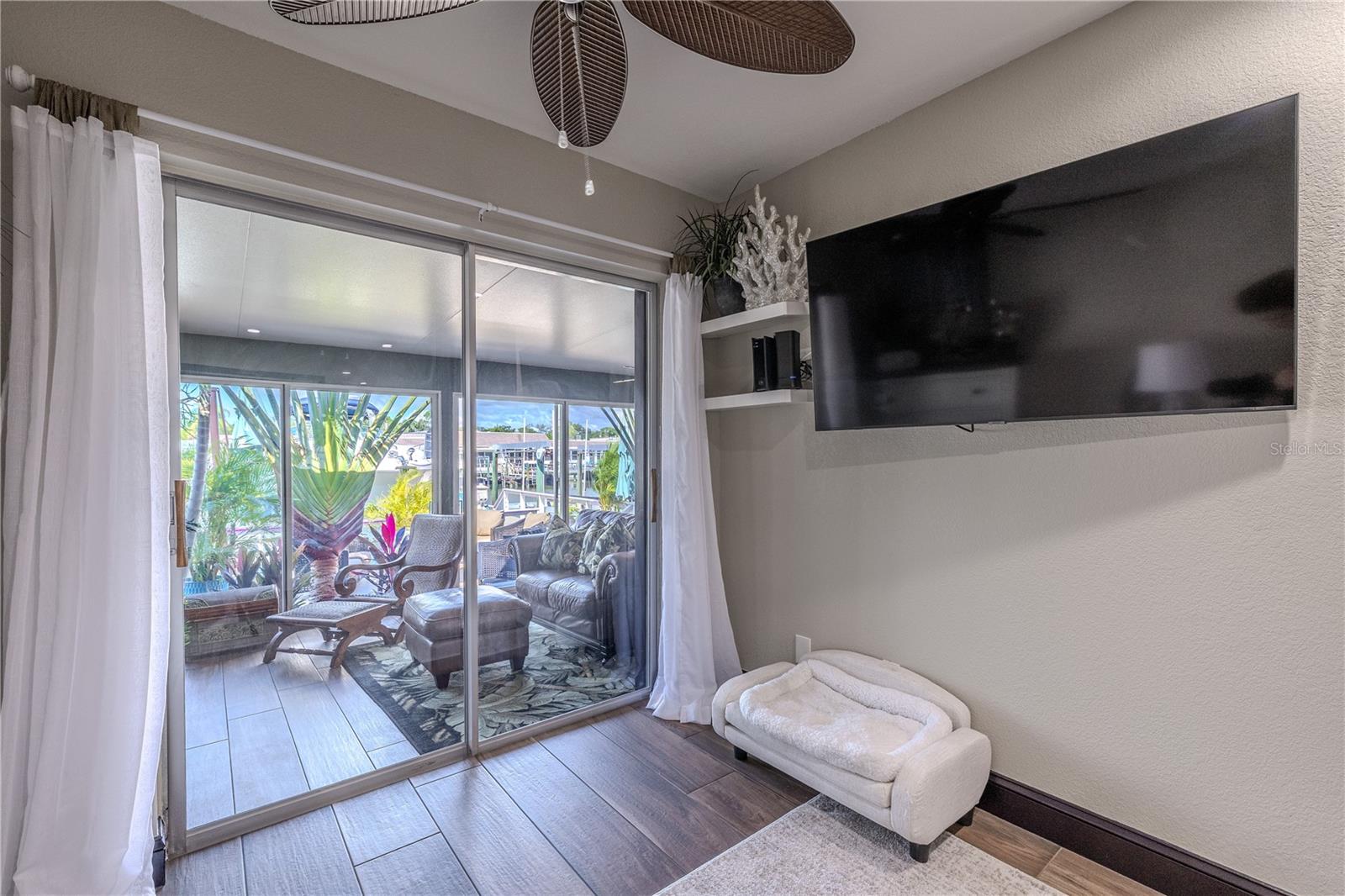 A cozy nook by the sliding glass doors offers the perfect spot for a small office, reading chair, or quiet corner to enjoy the waterfront view.