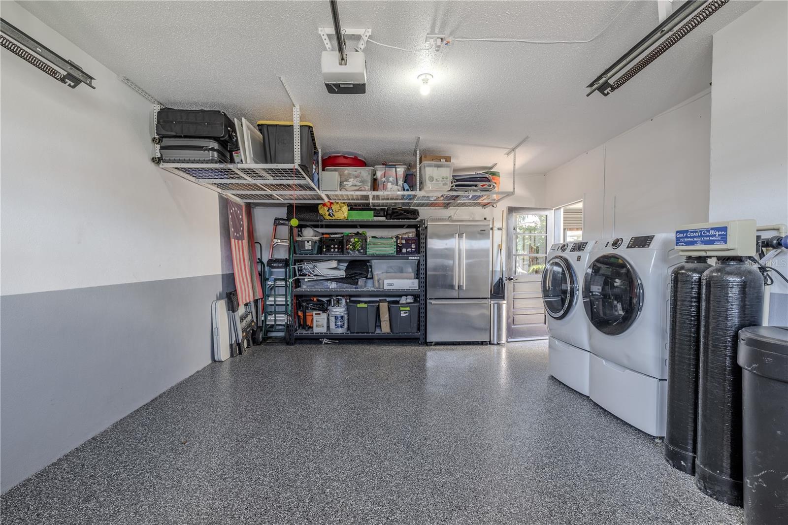The garage includes a new 2025 washer, 2021 dryer, organized shelving, and plenty of workspace for storage or hobbies.