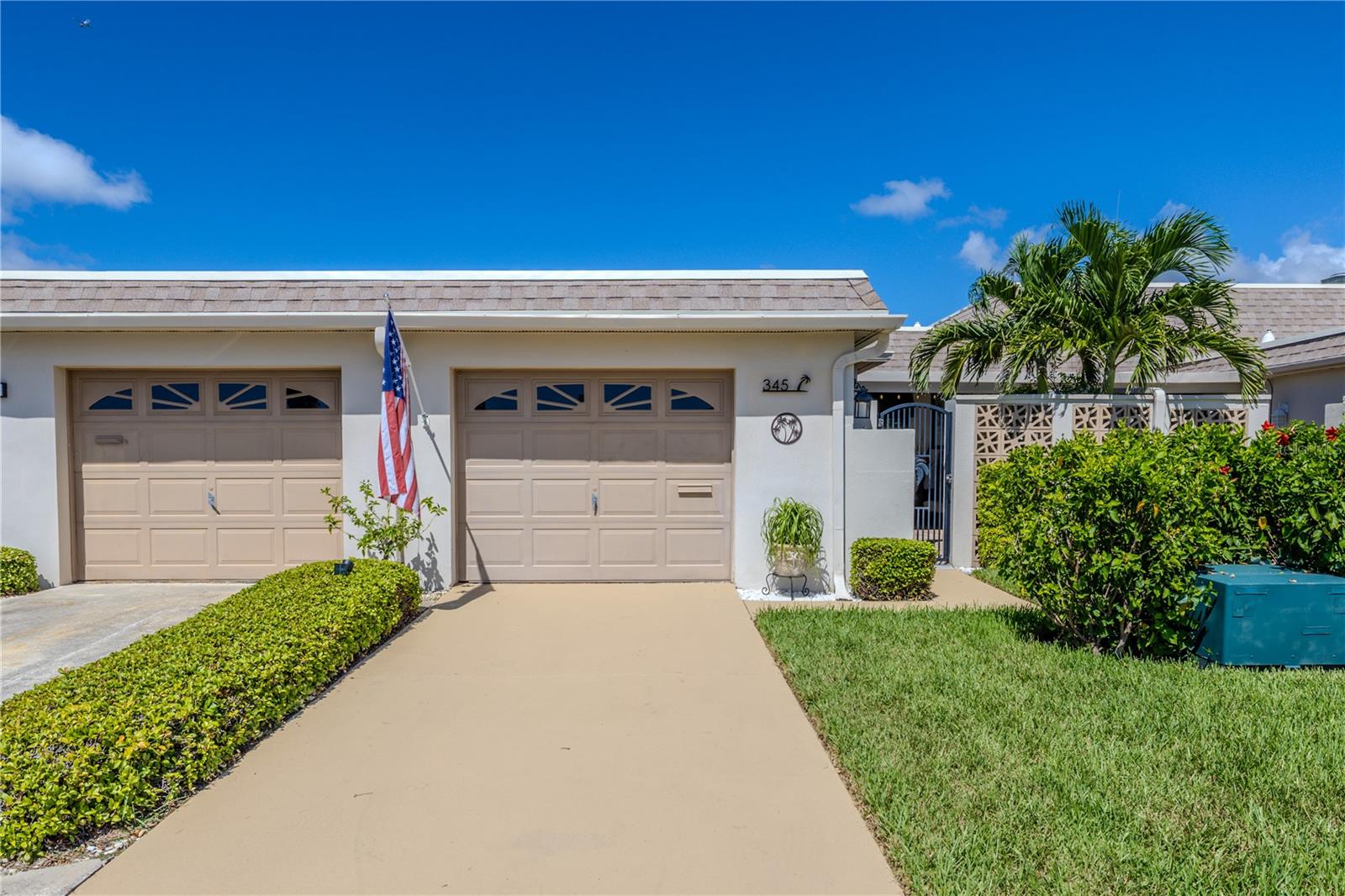 This waterfront villa features a new 2025 roof and a beautifully updated exterior with lush landscaping and a welcoming brick-paver courtyard entry.