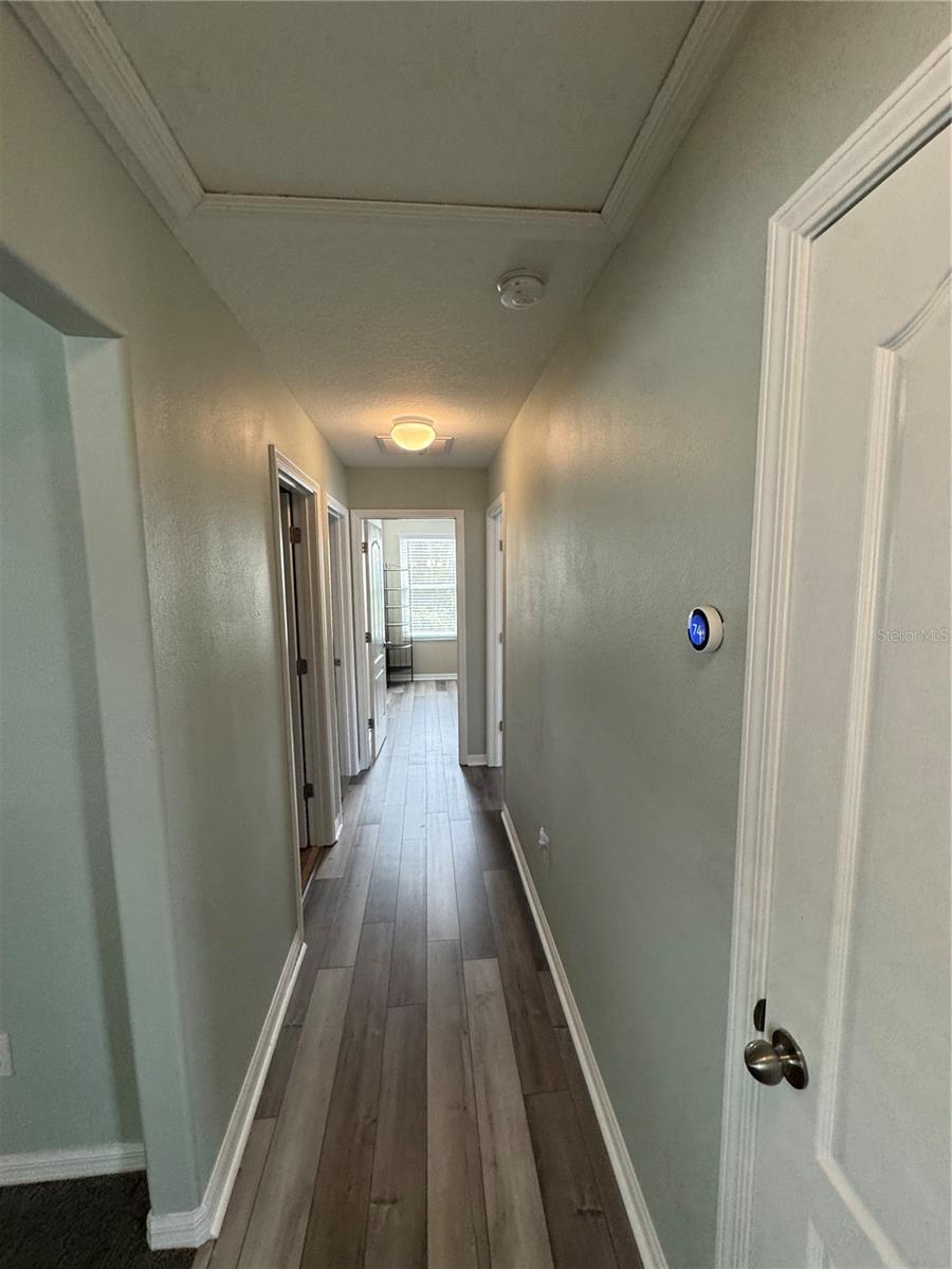 Hallway leading to three bedrooms and a full bath upstairs. Behind this hallway is the additional bedroom and full bath.