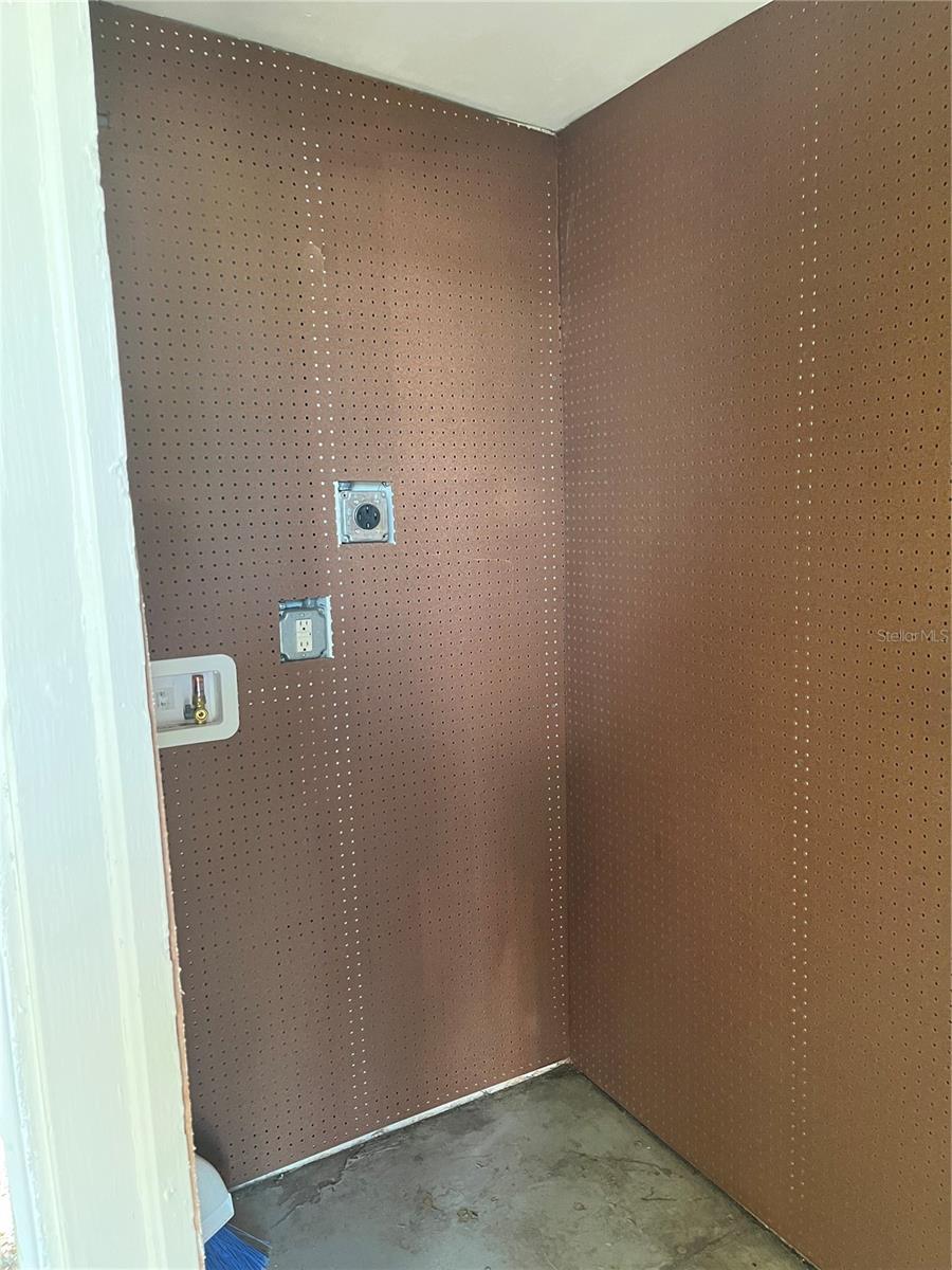 LAUNDRY/STORAGE/WATER HEATER CLOSET WITH PEG BOARD ALL AROUND