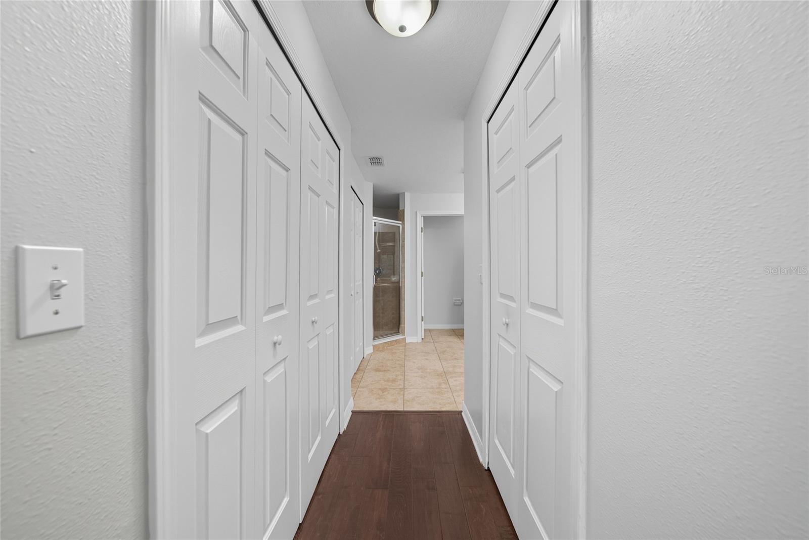 entrance to primary bathroom with 2 walk-in closets