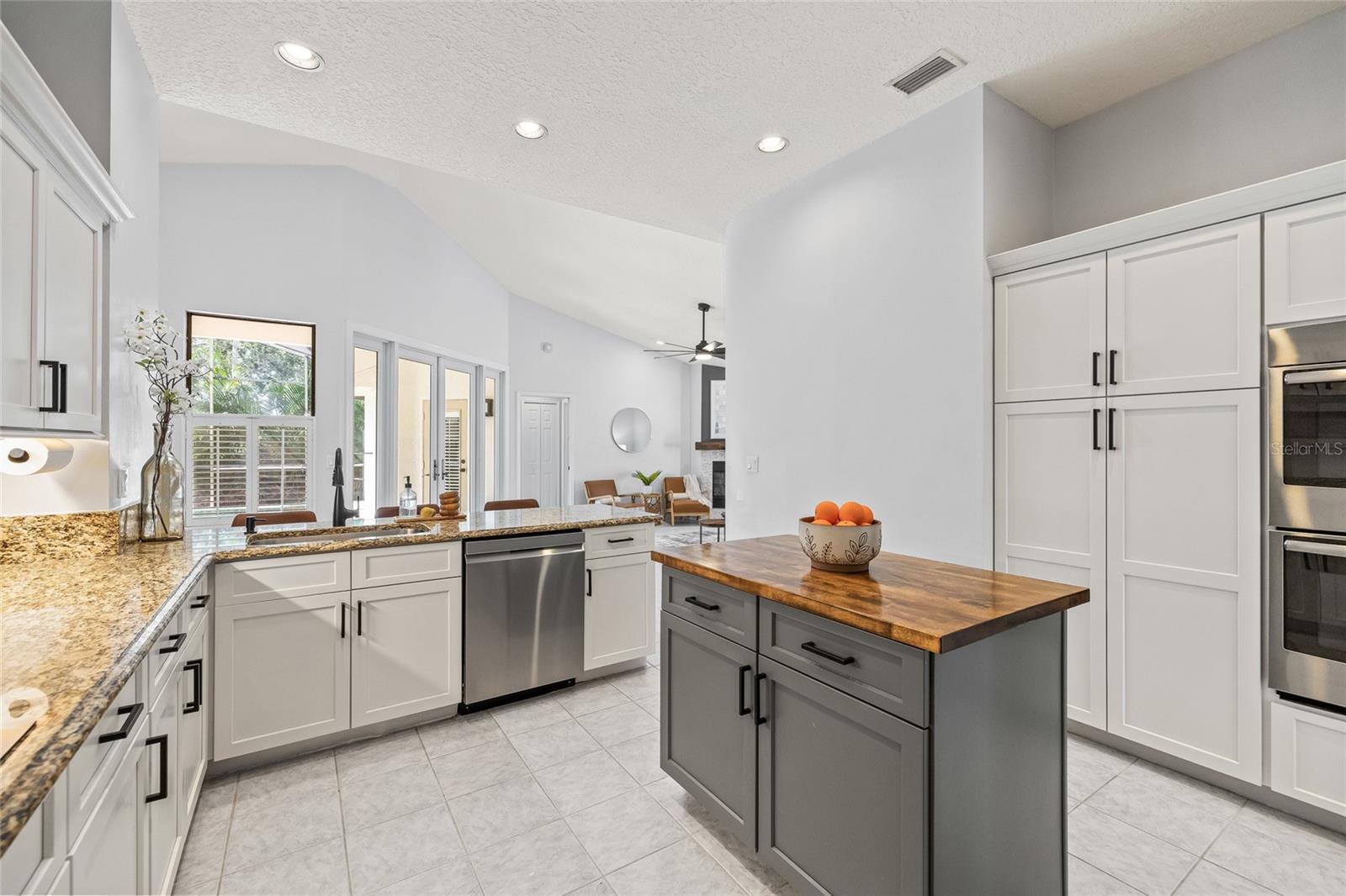 Updated kitchen with butcher-block island, double ovens and stainless steel appliances.