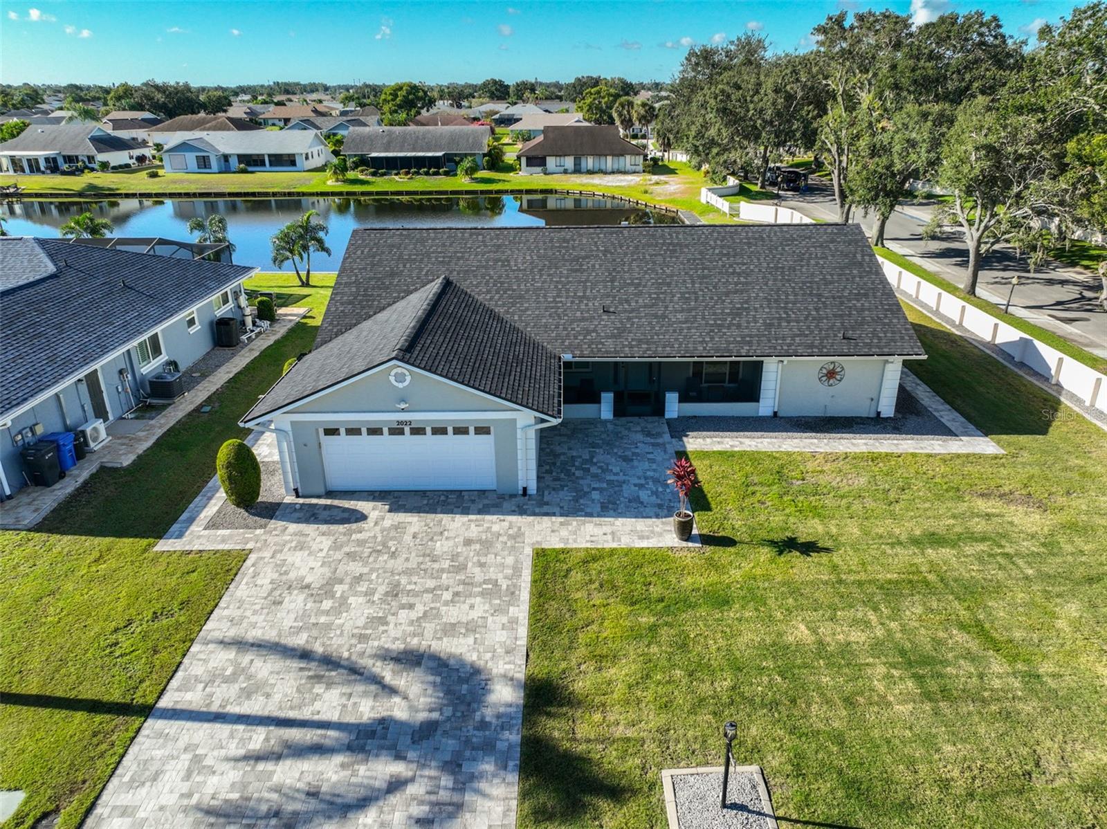 A water front, pool home on a large corner lot with a beautifully paved large driveway, walkways and an oversized 2 car garage that includes storage.