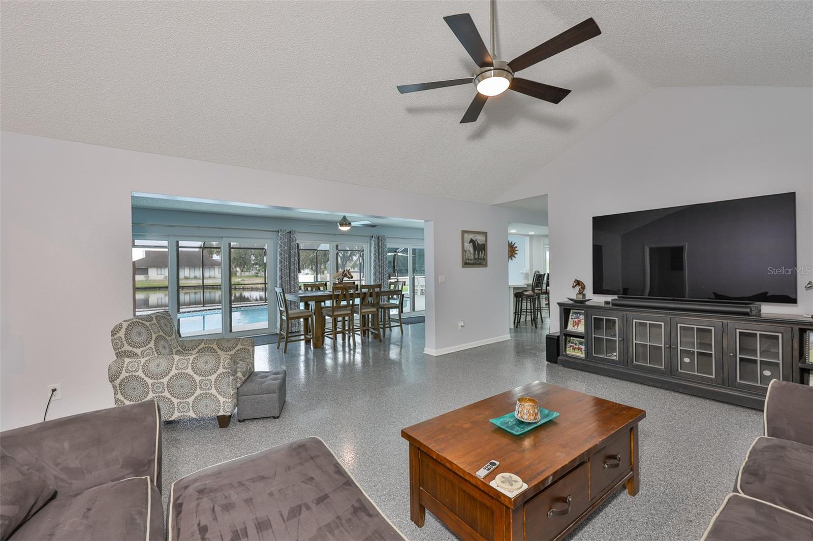 The wall of hurricane impact sliders and windows offer a stunning view of the pool and water features of this home.