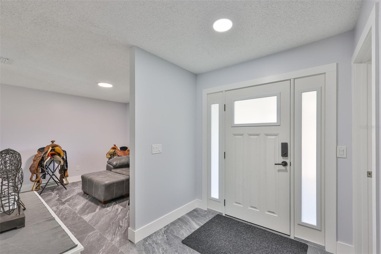 Tile and epoxy floors flow throughout the home making it ideal for swimmers, pets and family.  The living room is just off to the side as a comfortable reading room or perfect for cards.