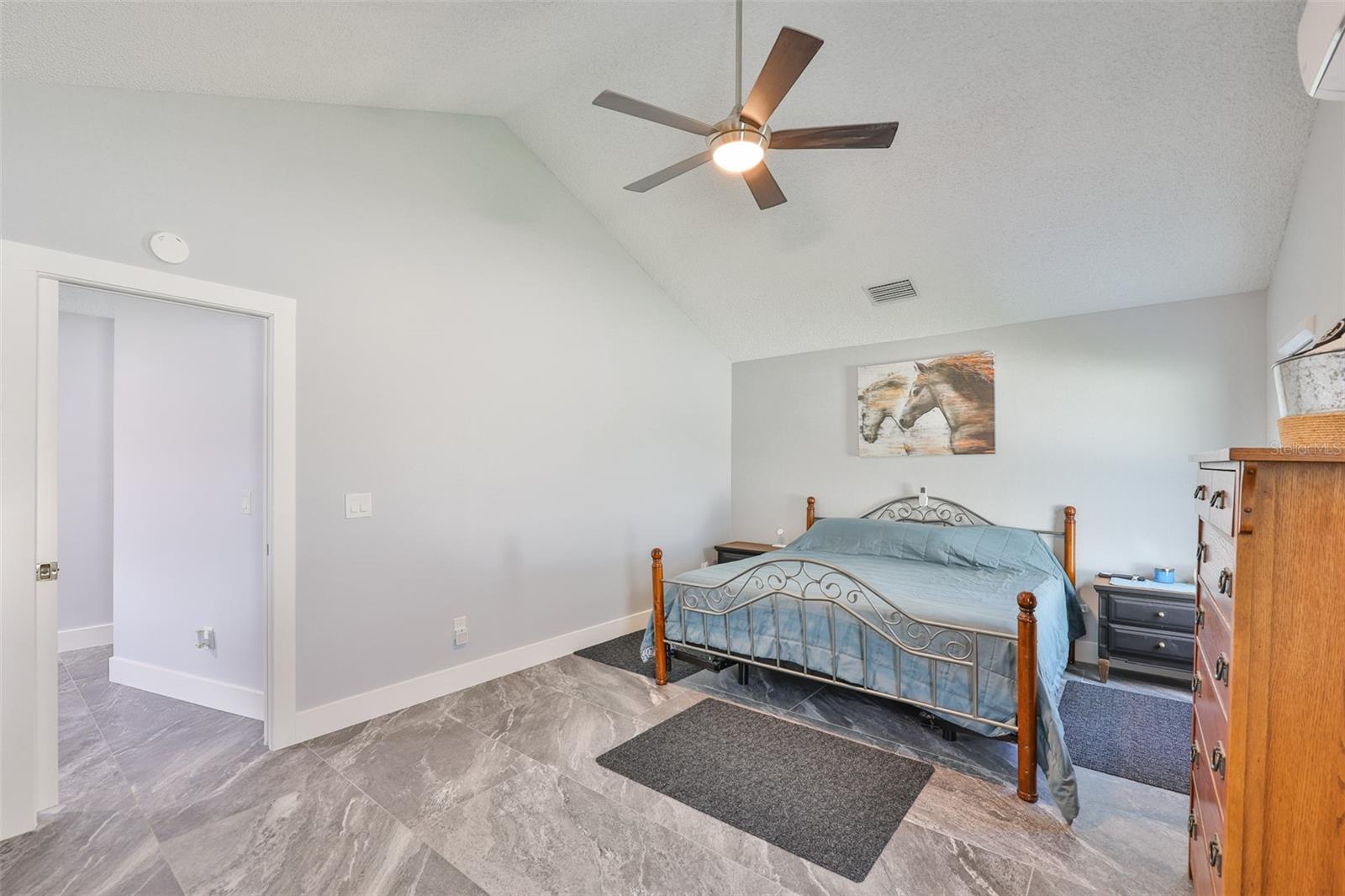 A huge bedroom with soaring ceilings and room for a king and lots of furniture.