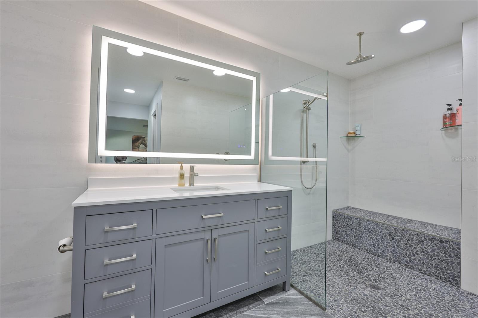 Fully remodeled ensuite bathroom from the master bedroom allows you to bathe in luxury with multiple shower heads and a cobblestone bench.