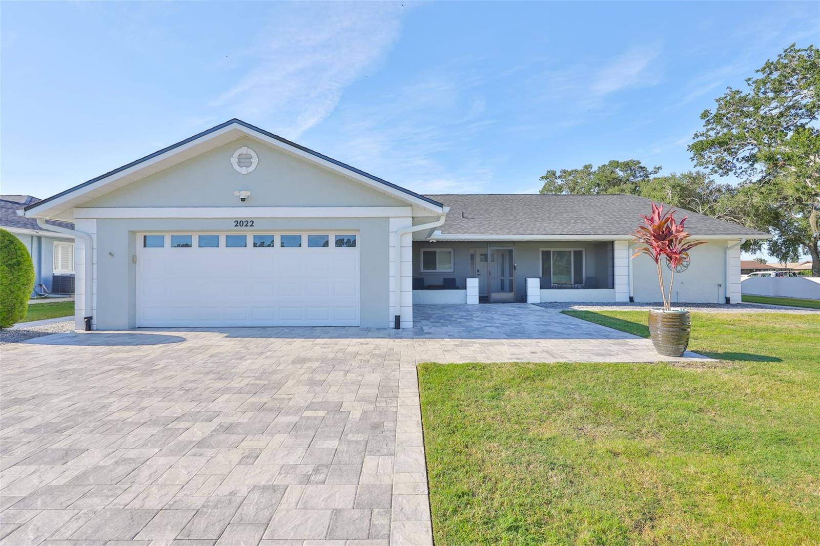 Modern pavers, crisp exterior painting and minimalistic landscaping make this a very contemporary home.