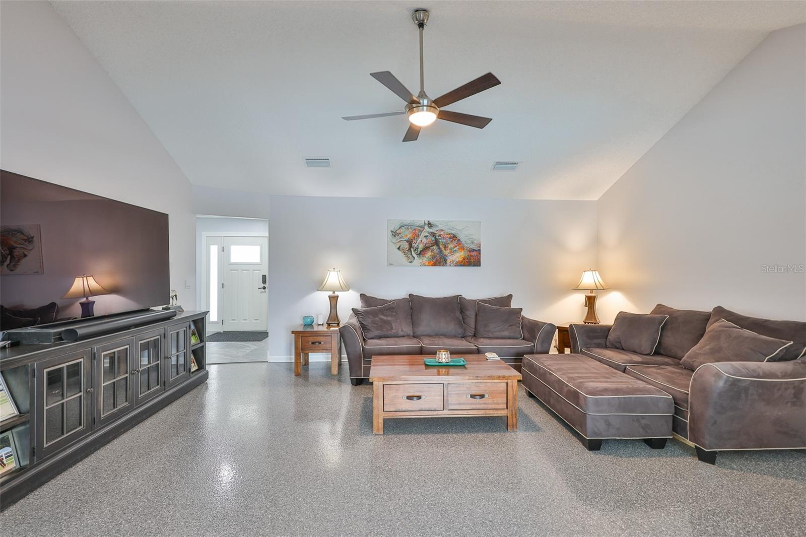 As you walk into the home, notice the soaring cathedral ceilings, epoxy flooring and wide open space.