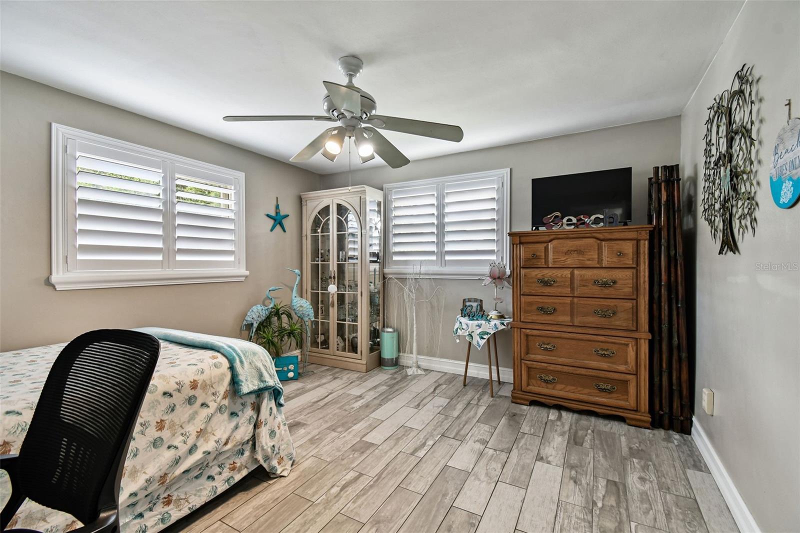 Bedroom 3 with porcelain tile floor and custom wood shutters.
