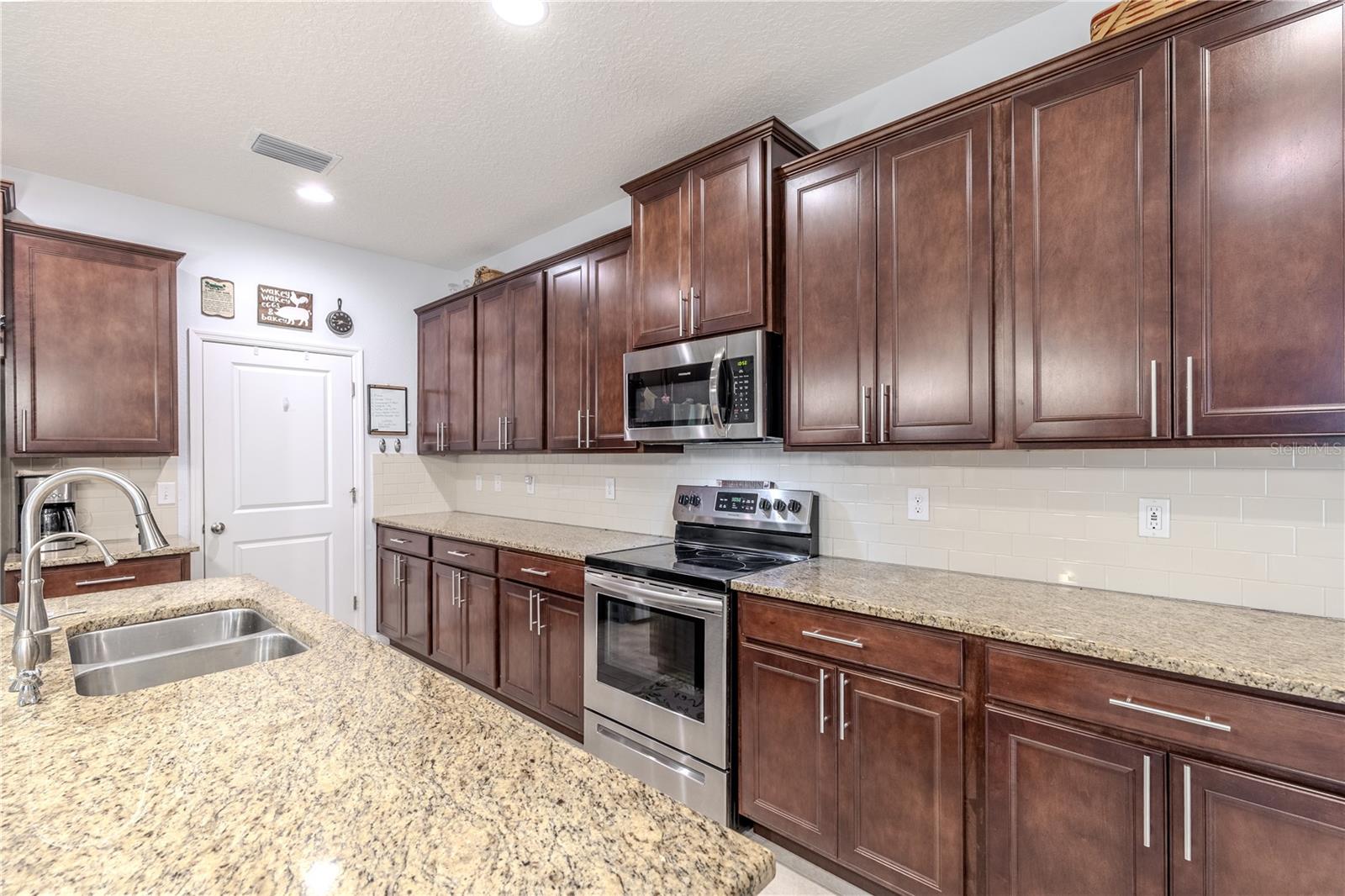 Bright kitchen with extended counter space, modern stainless appliances, and rich cabinetry that offers plenty of storage.