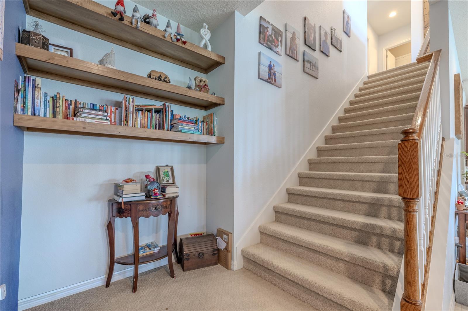 Open stairway with natural light and stylish railing leading to the upper level and spacious bonus area.