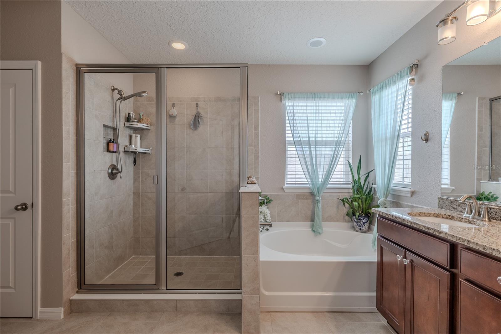 Primary ensuite featuring a large walk-in shower, granite vanity, and elegant finishes that create a relaxing, spa-like feel.