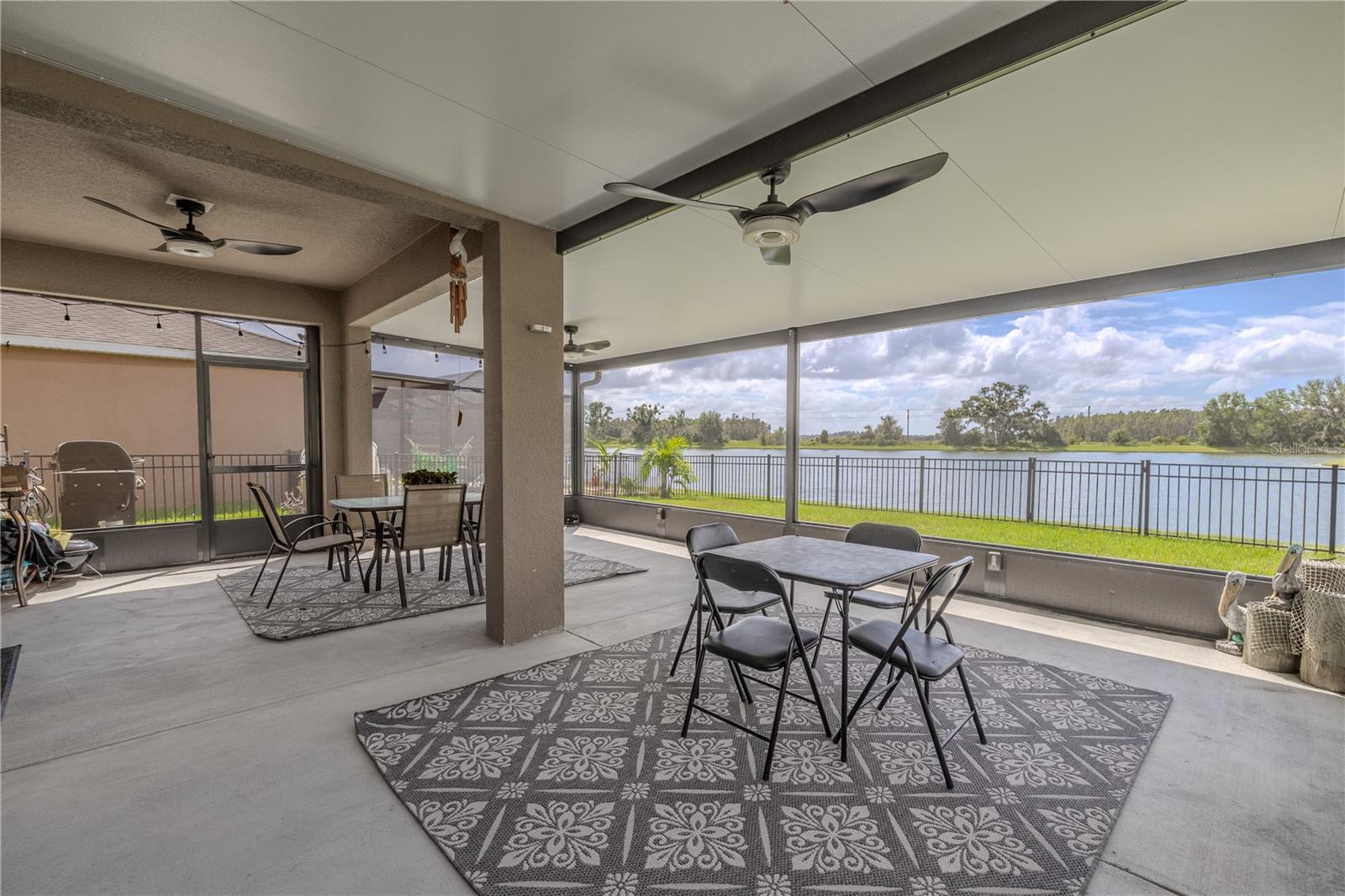 Screened-in lanai overlooking the water, creating an ideal space for relaxing or enjoying meals outdoors.