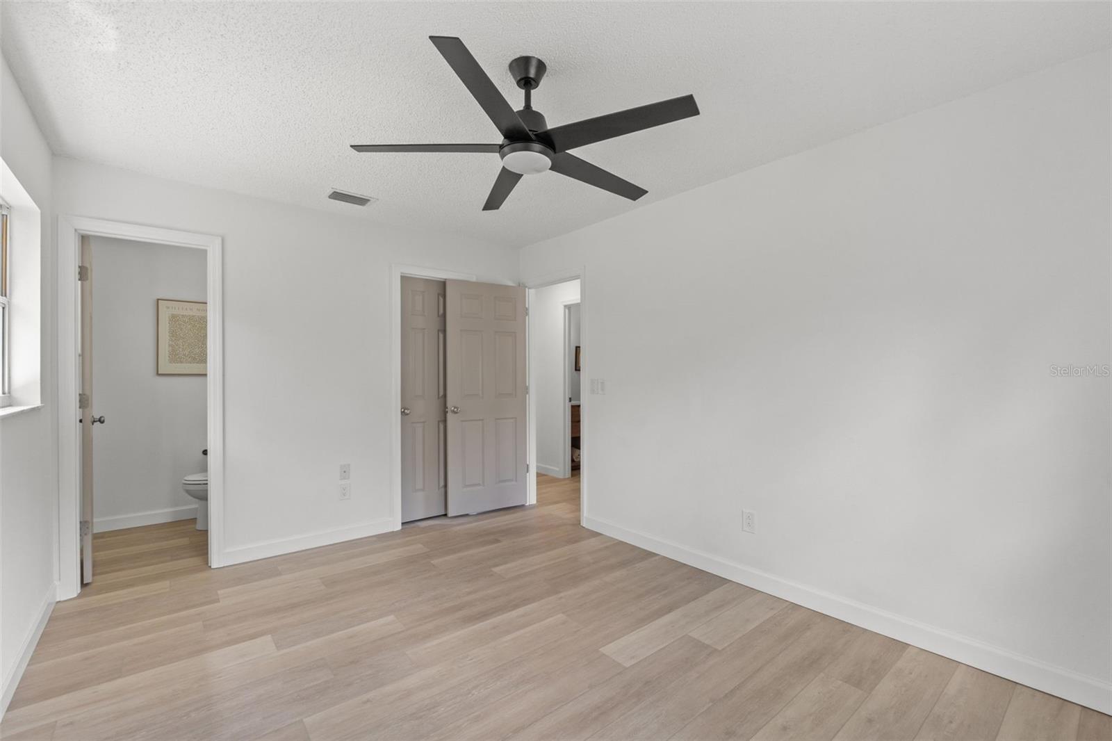 Primary bedroom with attached half bath and walk-in closet