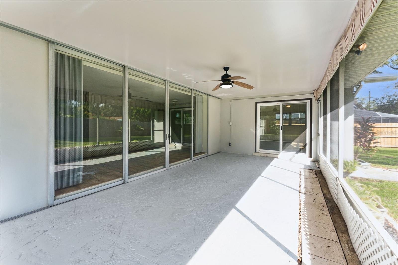 Seamless indoor-outdoor living! The screened-in back porch connects to the living room through sliding glass doors, perfect for entertaining or relaxing