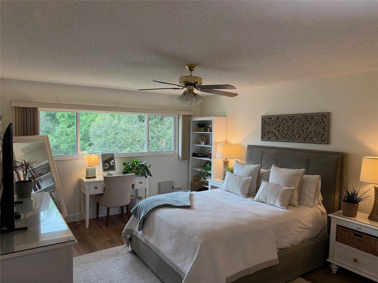 The massive window in the Primary bedroom provides the same serene view as the Florida room.