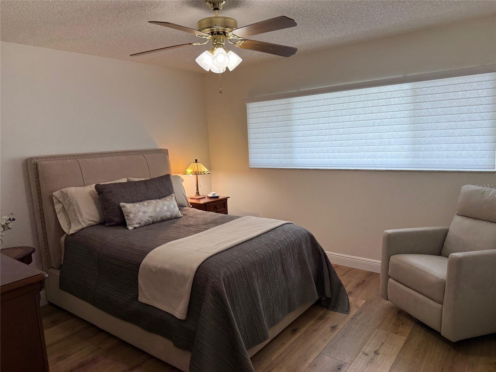 The guest bedroom is also spacious and mirrors the decor of the primary bedroom.  This spacious window looks to the front of the complex and provides a peek a boo view of Arbor Lake.  Guest room offers two closets.