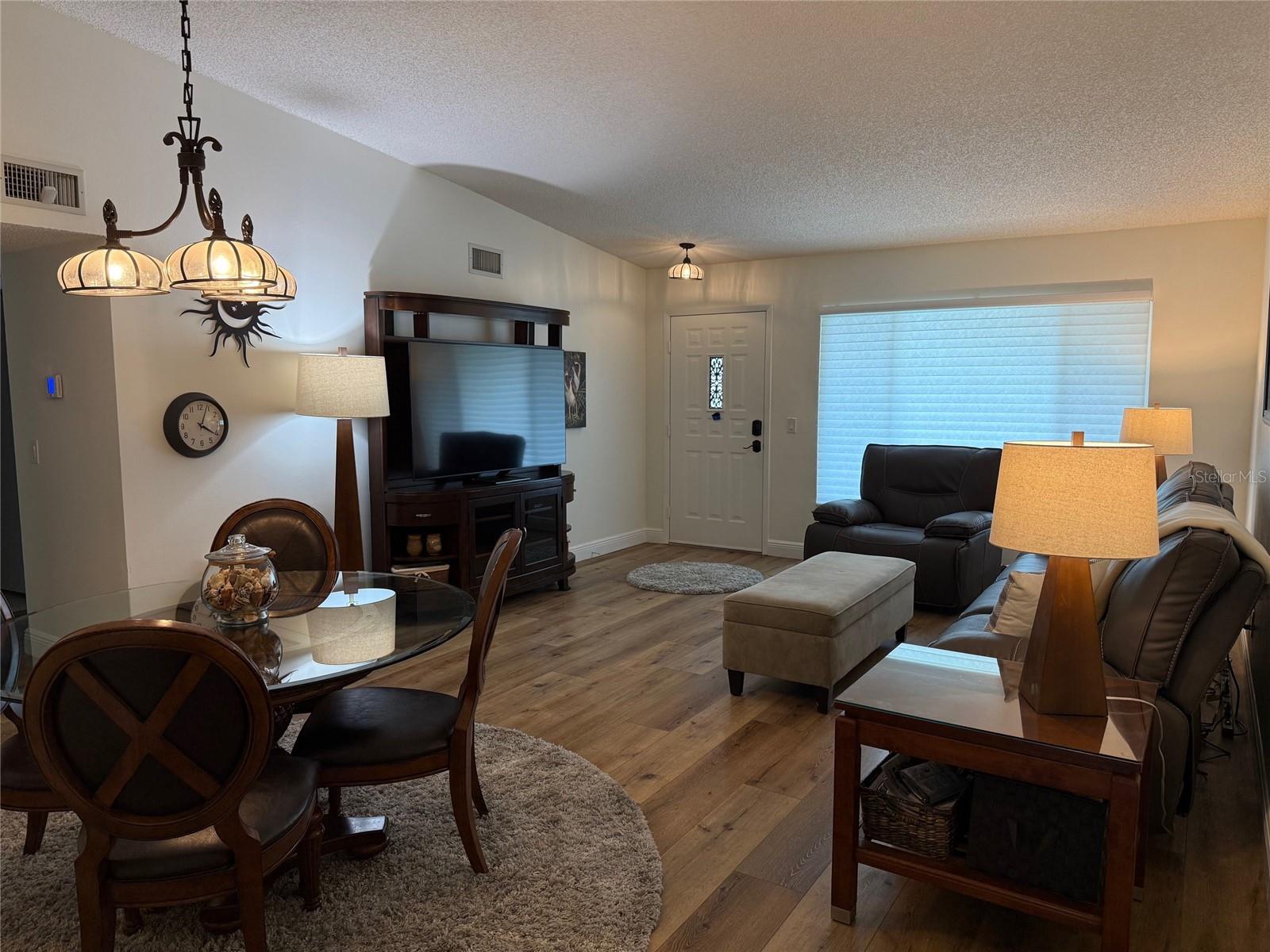 Inside offers two living areas:  Living & Dining room area and the kitchen/Florida room area.  View of front entry from hall connecting both living areas. The front window looks out towards Arbor Lake.