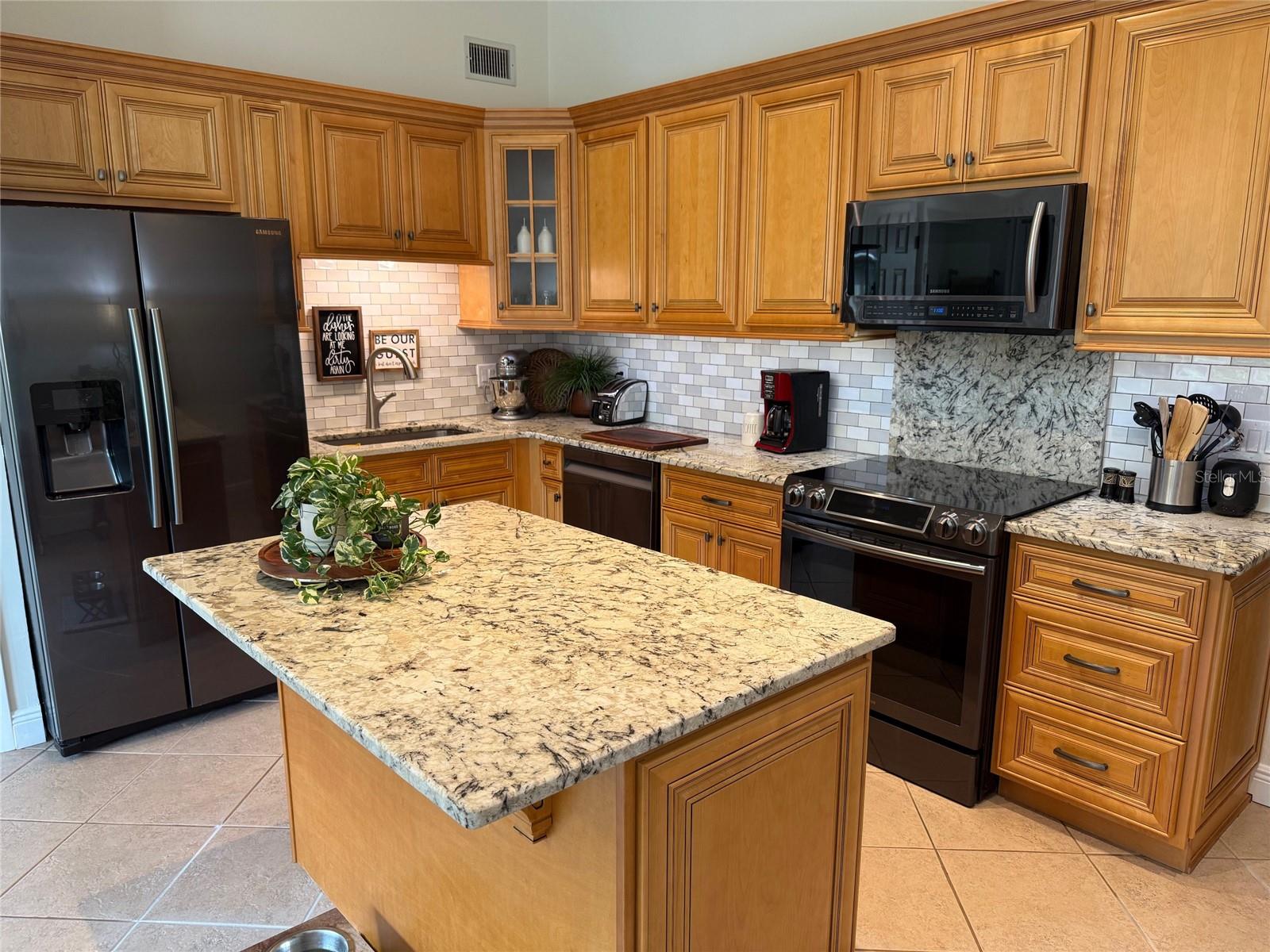Appliances include side by side refrigerator w/ice maker, cooktop range, microwave hood & dishwasher. There is also a disposal and stainless sink.