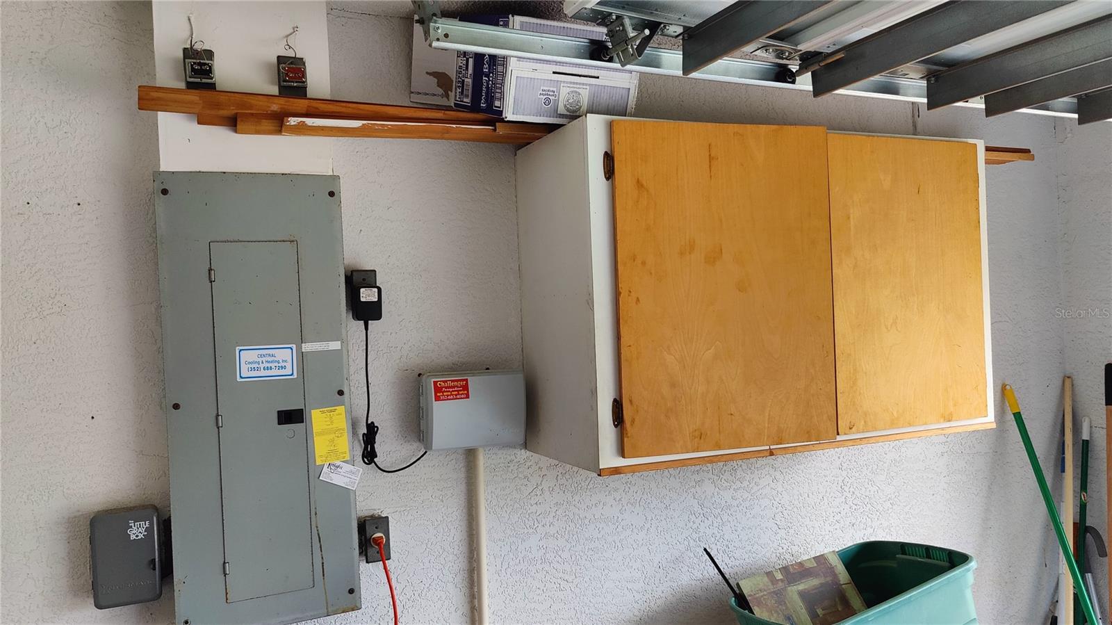 Storage cabinets, sprinkler control box and circuit breaker panel all located inside the garage