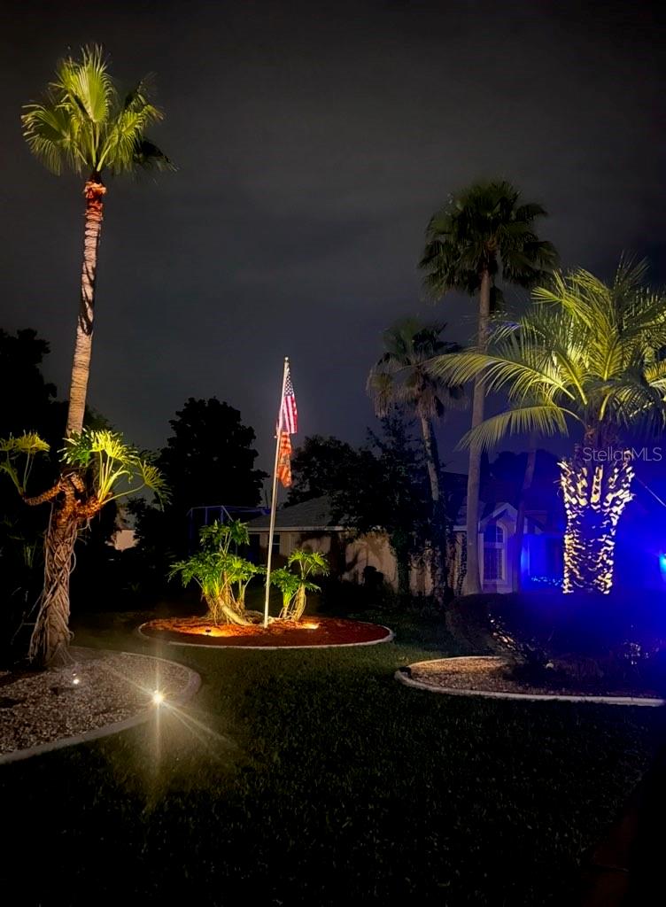 Right side of house at night has lovely accent lighting and a lighted flag you never have to take down.