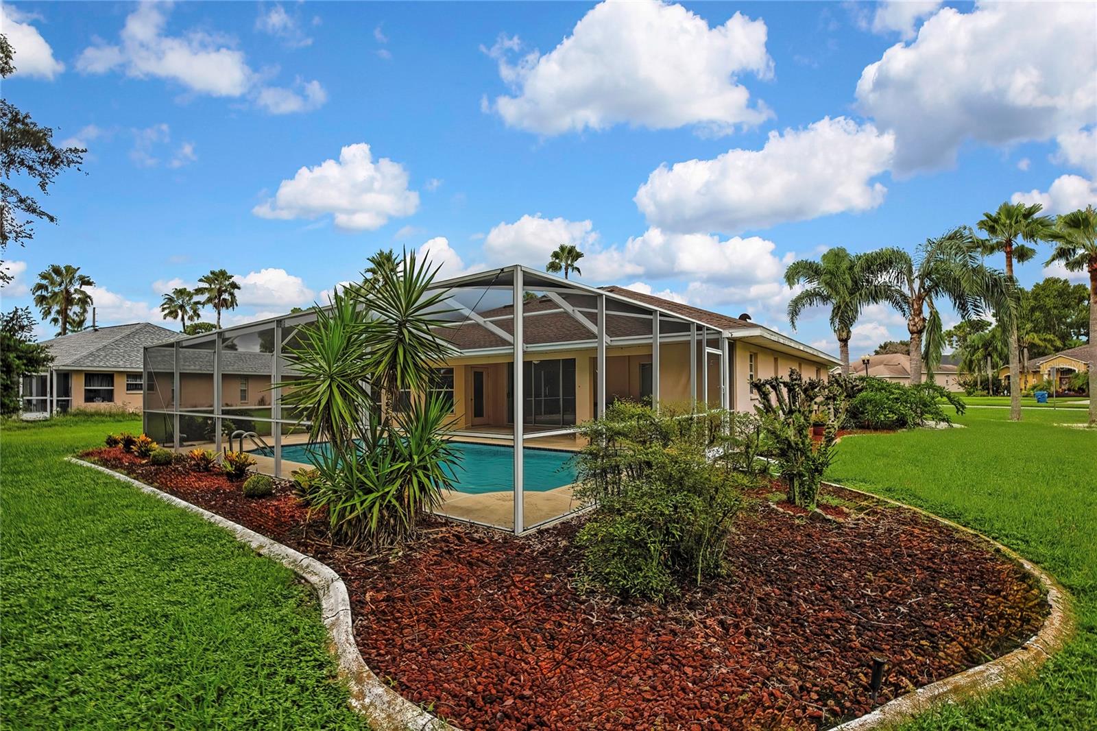 Left side and rear of home have lovely flower gardens to accent the in ground pool.