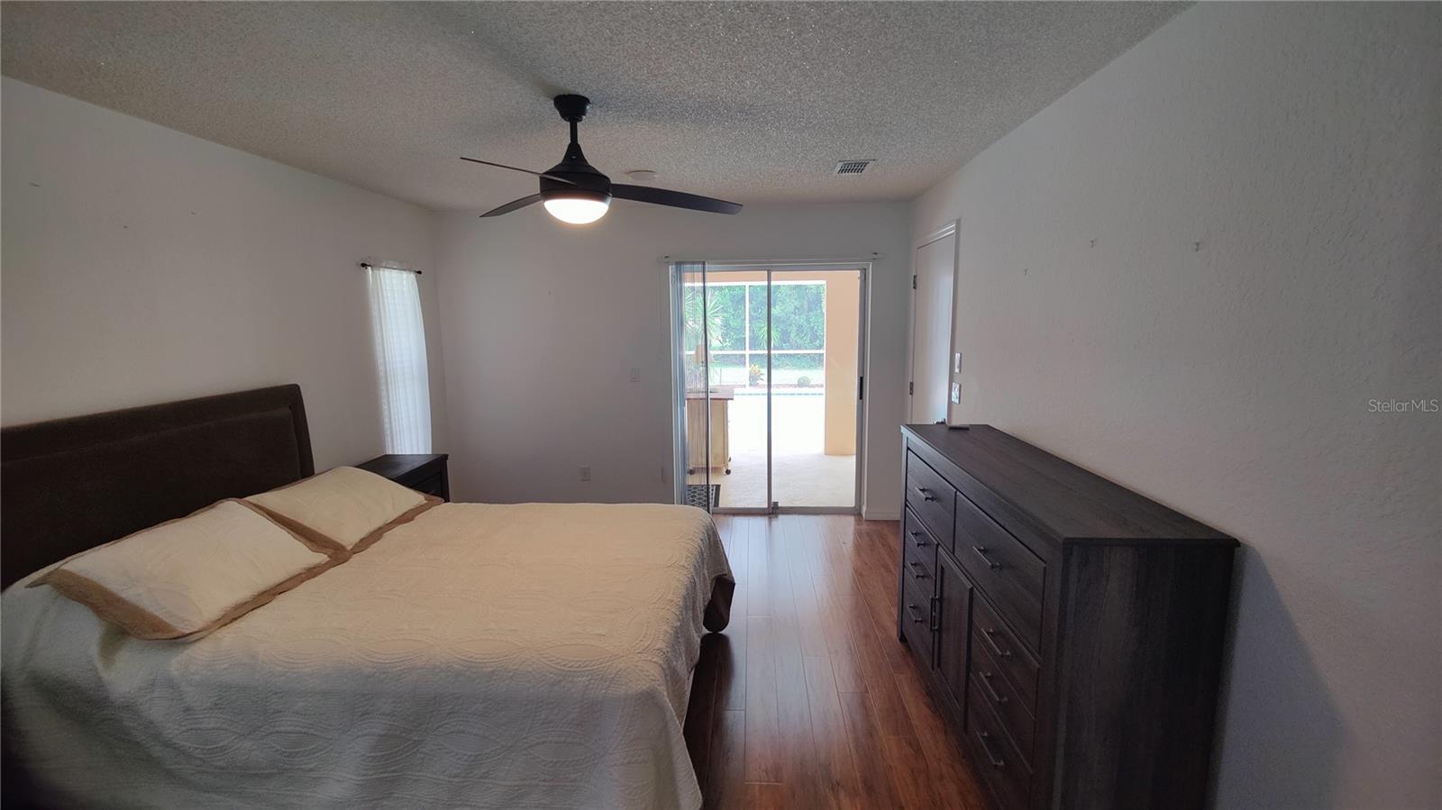 Primary bedroom boasts a pool view.  It's like living in a vacation wonderland all the time.