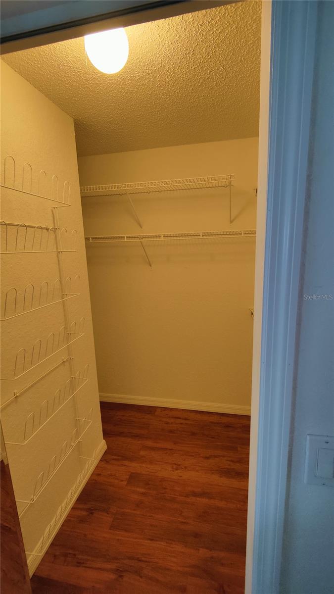 Walk in closet has shoe rack and lots of shelfs and hanging space to help keep things organized and relieve stress