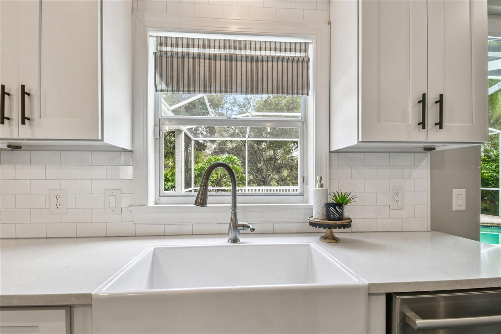 An excellent view of the pool, yard and nature from the kitchen sink