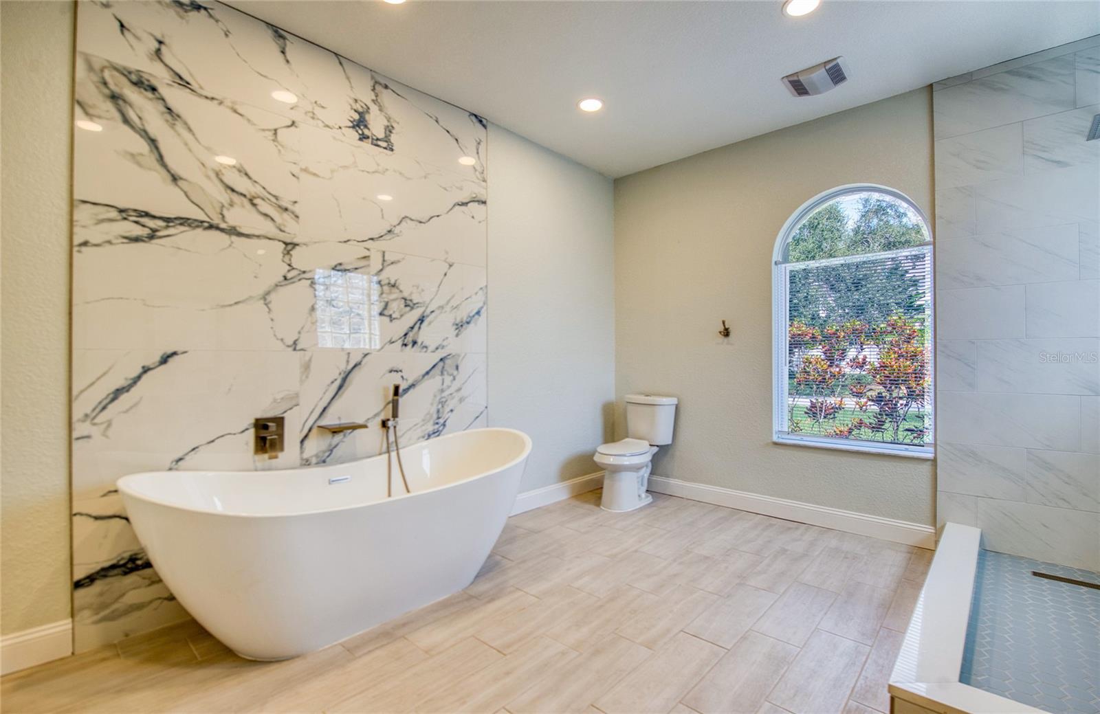 Spacious main bath with tub, shower, and granite feature