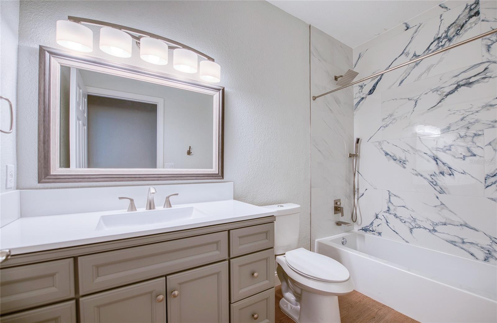 Beautiful second bath with tub-shower combo and granite feature