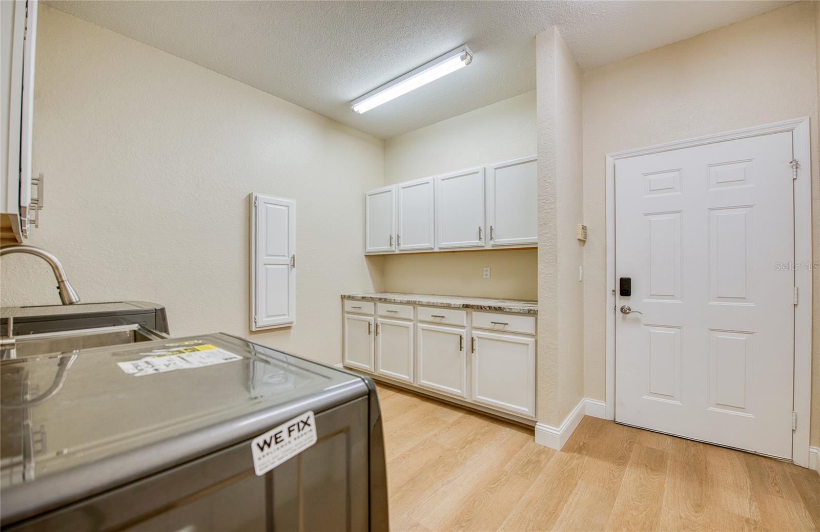 Huge laundry room includes washer, dryer, and work space with pantry and lots of storage