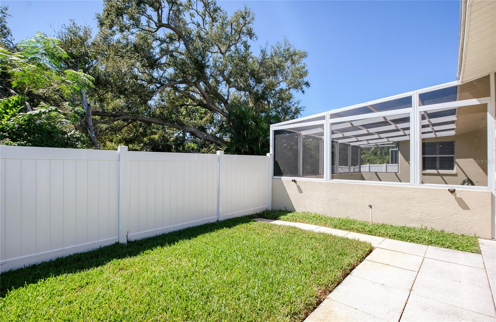 Fenced in back yard with doggy run on other side of lanai