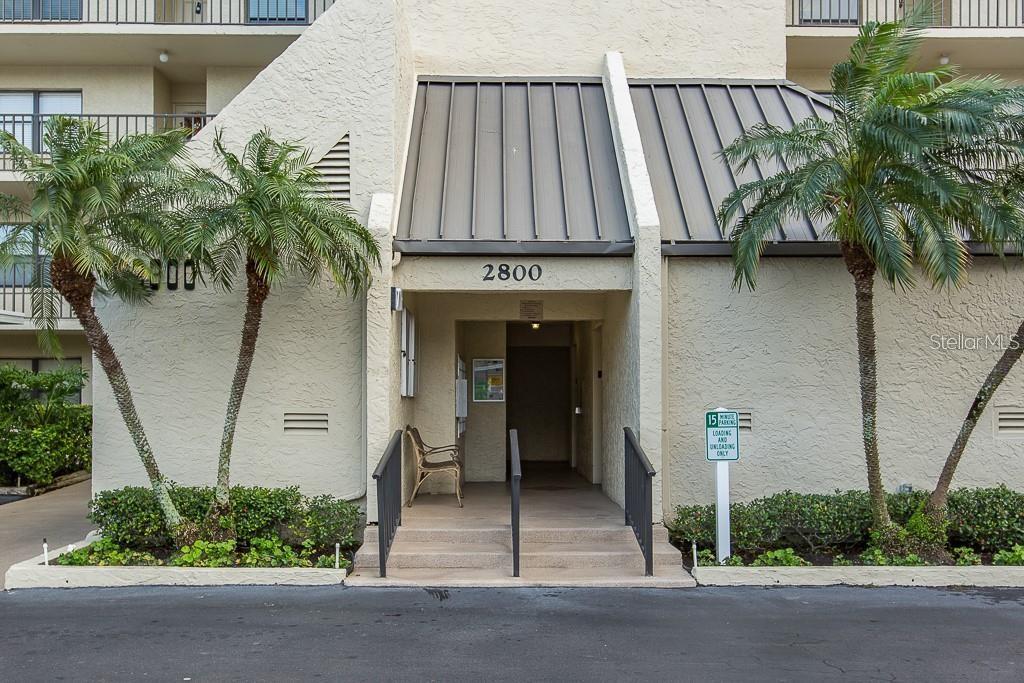 Front entry to elevator, surrounding lush Florida landscaping.
