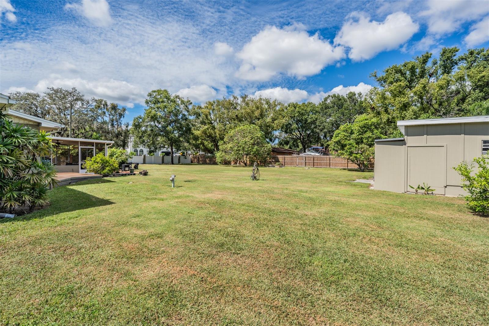 Large fenced yard with worshop to the right.