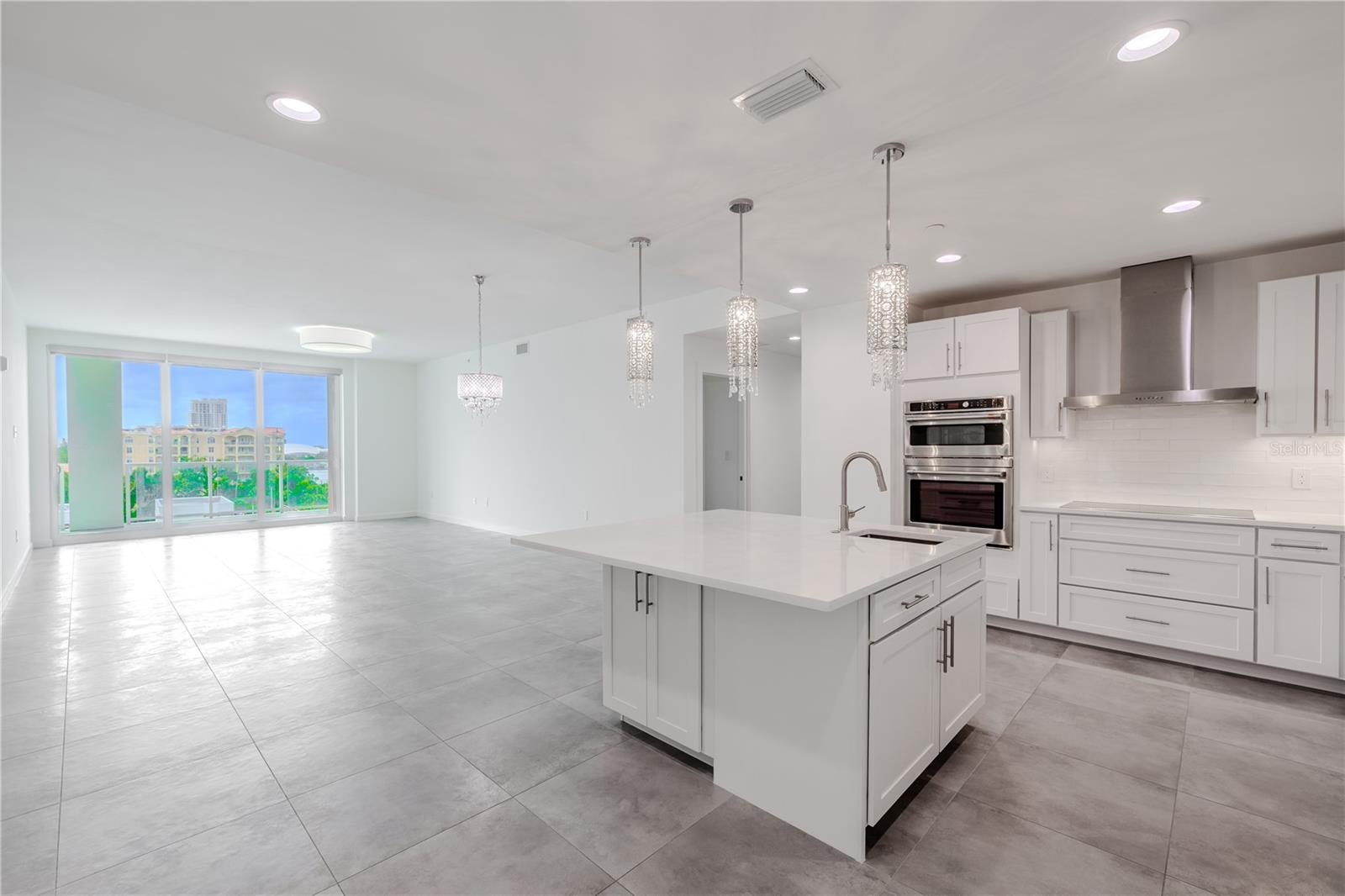 This stunning open-concept layout seamlessly connects the kitchen, dining, and living areas, creating a bright and inviting space ideal for entertaining.