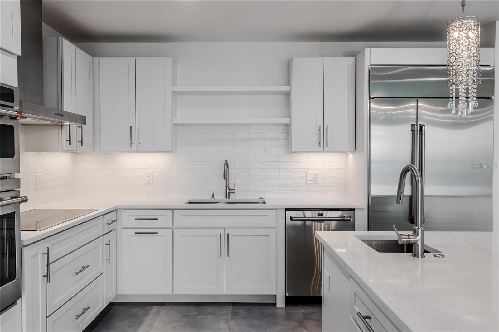 Under-cabinet lighting and open shelving complete this show-stopping culinary space.