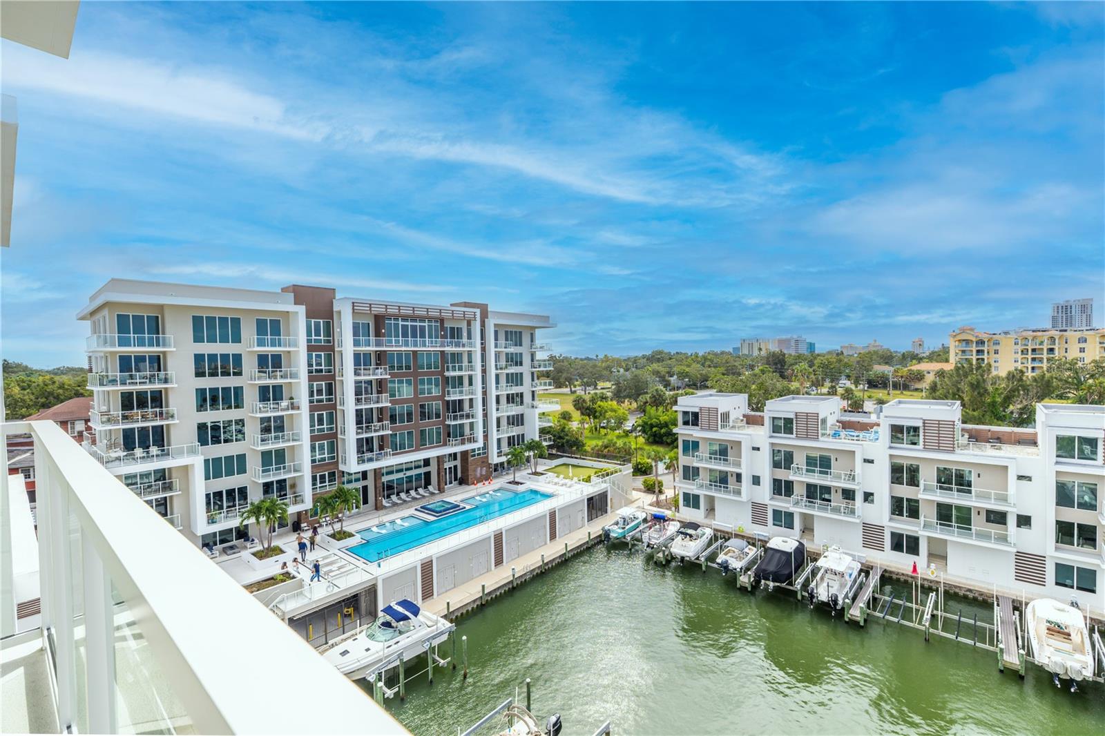 Look southeast for a view of the 25 meter lap pool with hot tub, outdoor fire table, BBQ and dining areas, outdoor putting green, and the full service marina.