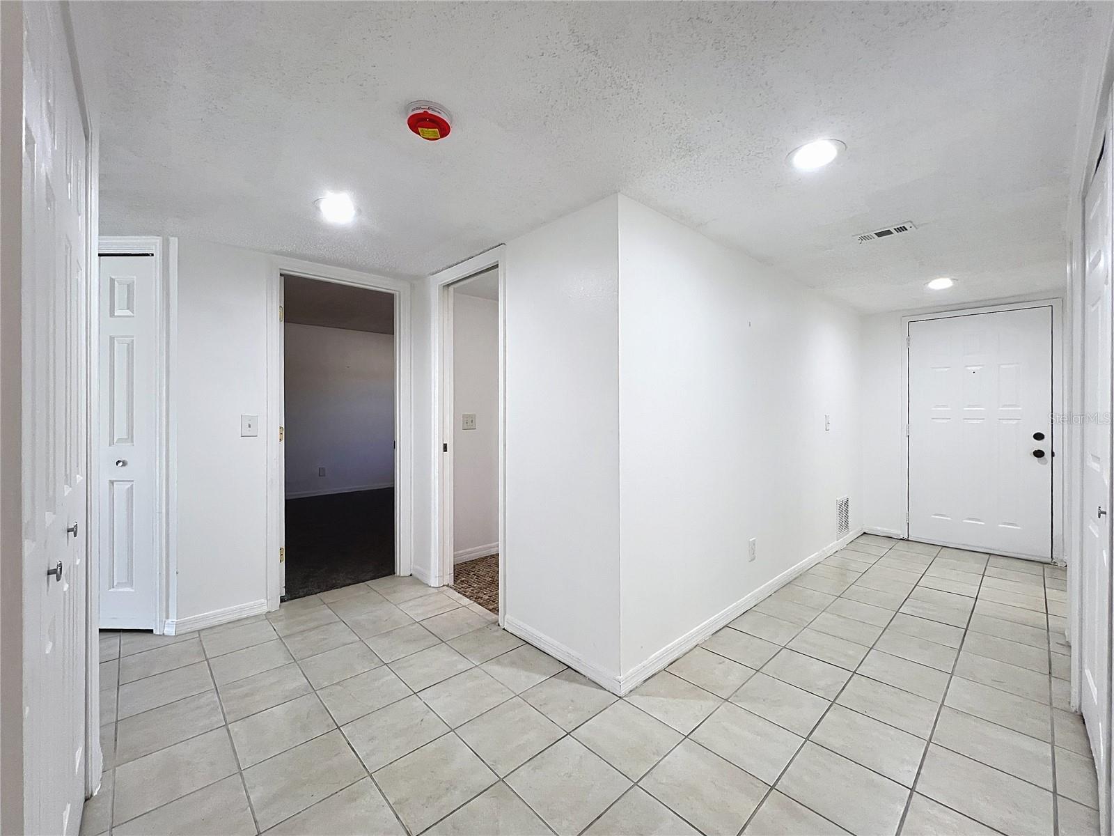 Hallway leading to front door and bedrooms and baths.
