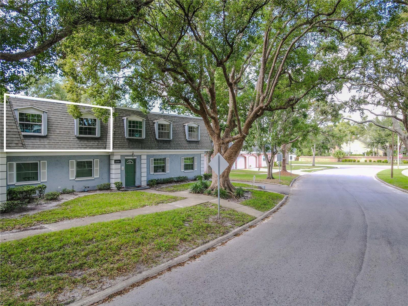 This 2 bedroom, 1 bath condo on Belleair Forest Drive  presents timeless charm with a classic, colonial-style façade framed by mature, shade-giving oak trees.  The property sits on a quiet, tree-lined curve, offering a peaceful residential feel.
