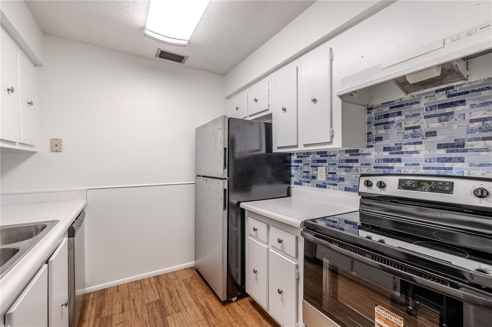 This  kitchen features an efficient layout and bright, clean design with white cabinetry and countertops creating a crisp backdrop