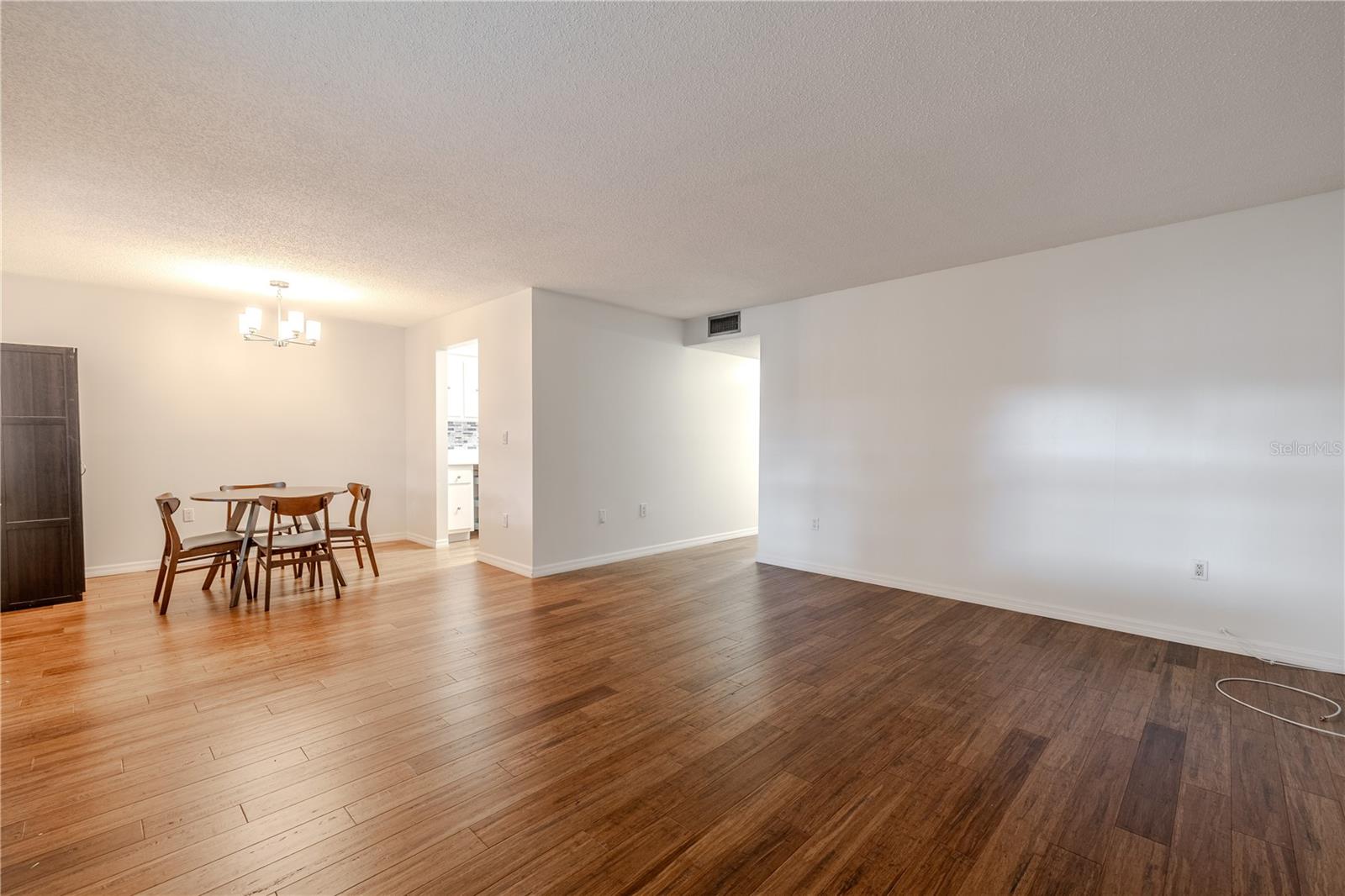 This spacious living and dining area offers an open, inviting layout with beautiful bamboo floors that flow seamlessly throughout the space.