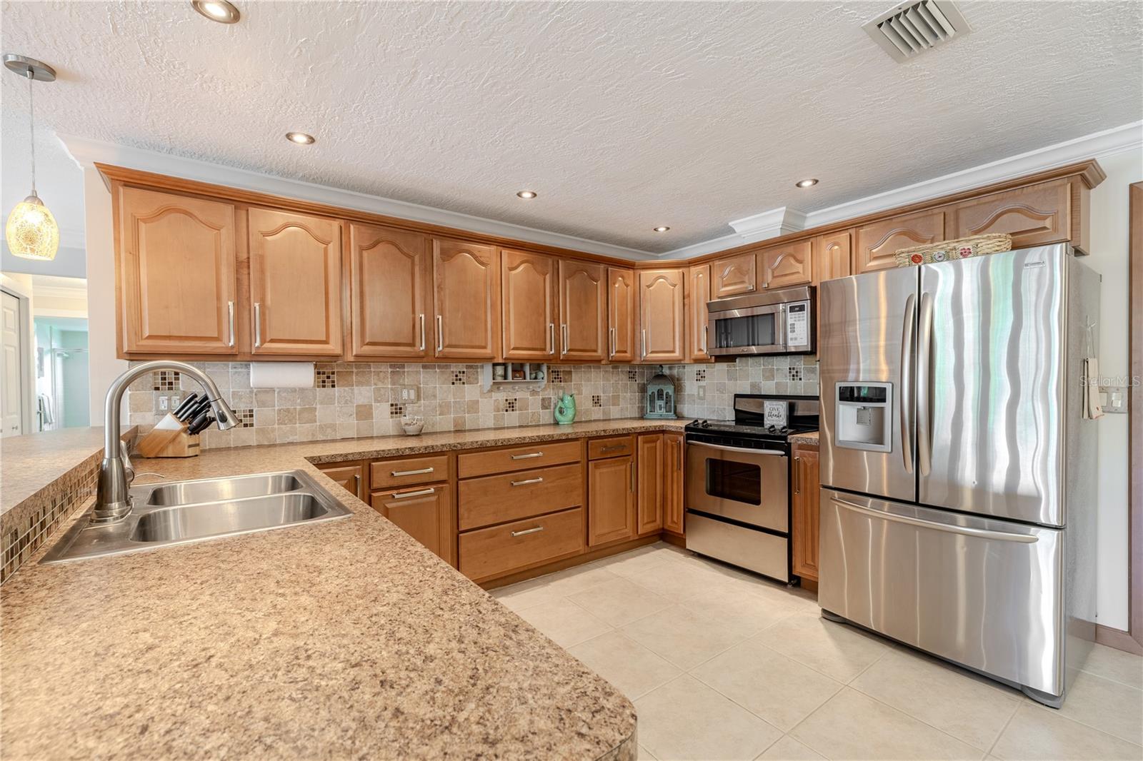 Well-equipped kitchen featuring stainless steel appliances, a walk-in storage pantry, and convenient garage access.