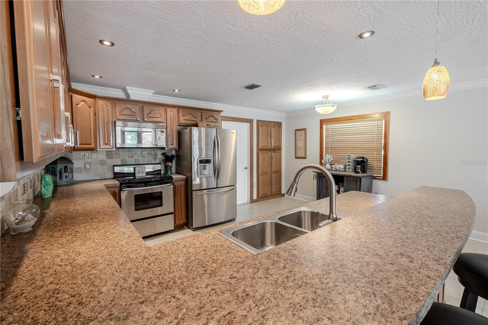 Updated kitchen featuring stainless steel appliances, generous cabinet storage, and a breakfast bar.