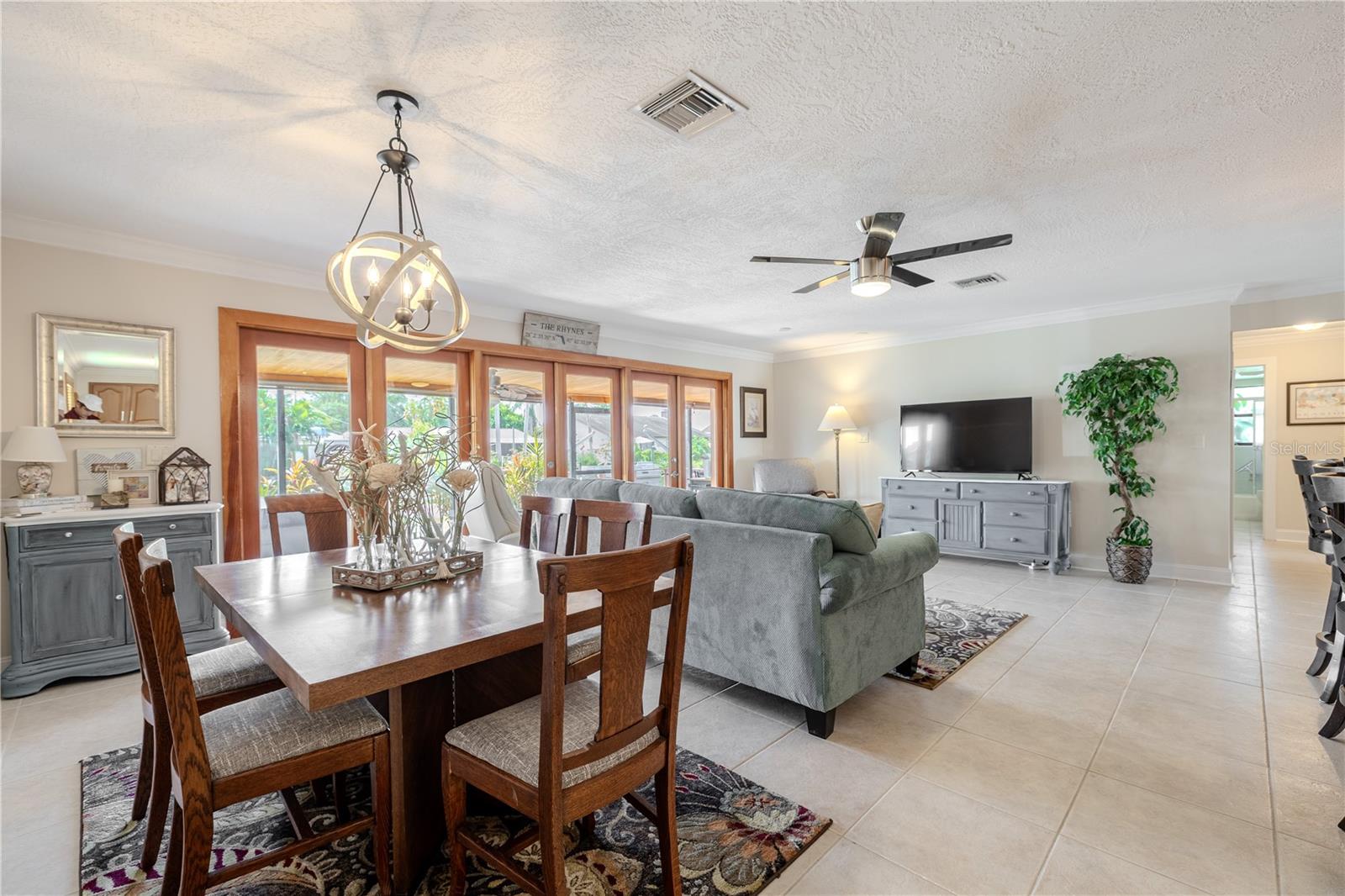 Dining area framed by wood-trimmed glass doors that fill the space with natural light and canal views.